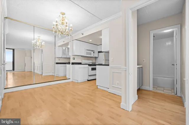 a large white kitchen with cabinets and stainless steel appliances