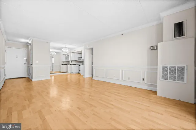 a view of empty room with wooden floor