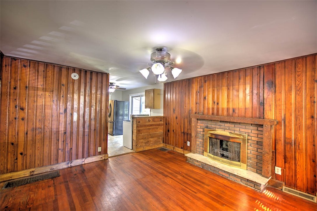 7450 West William Street Decatur, IL 62522 - Photo 4 of 18 an empty room with wooden floor fireplace and windows