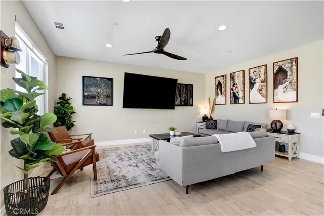 a living room with furniture a flat screen tv and a potted plant