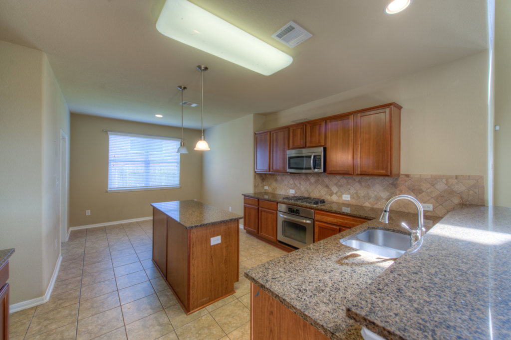 403 Limestone Trail Austin, TX 78737 - Photo 11 of 18 A well-appointed kitchen features rich wood cabinetry, granite countertops, and modern stainless steel appliances.