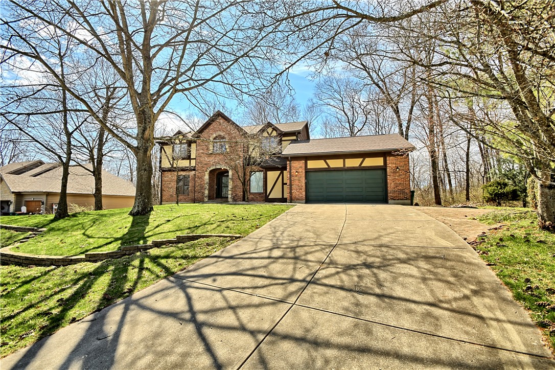 This charming residence features a brick and timber-frame facade, offering ample parking and a lush, expansive lawn.