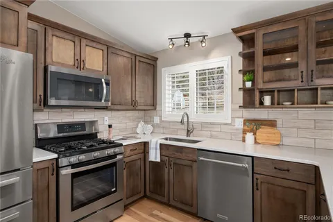 a kitchen with stainless steel appliances granite countertop a sink stove microwave and cabinets
