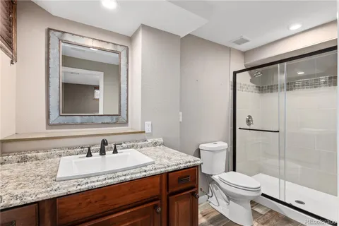 a bathroom with a granite countertop sink toilet and shower