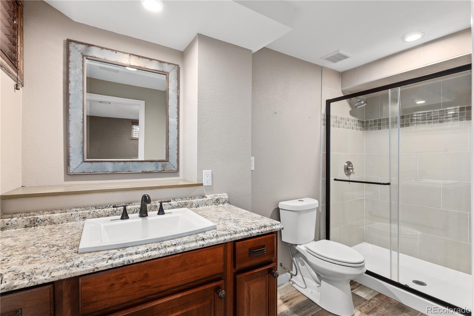 3920 Collins Street Castle Rock, CO 80108 - Photo 28 of 40 a bathroom with a granite countertop sink toilet and shower