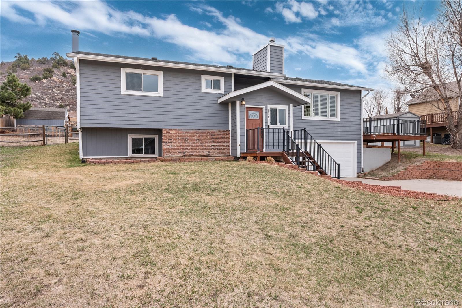 3920 Collins Street Castle Rock, CO 80108 - Photo 3 of 40 a front view of a house with a yard and garage
