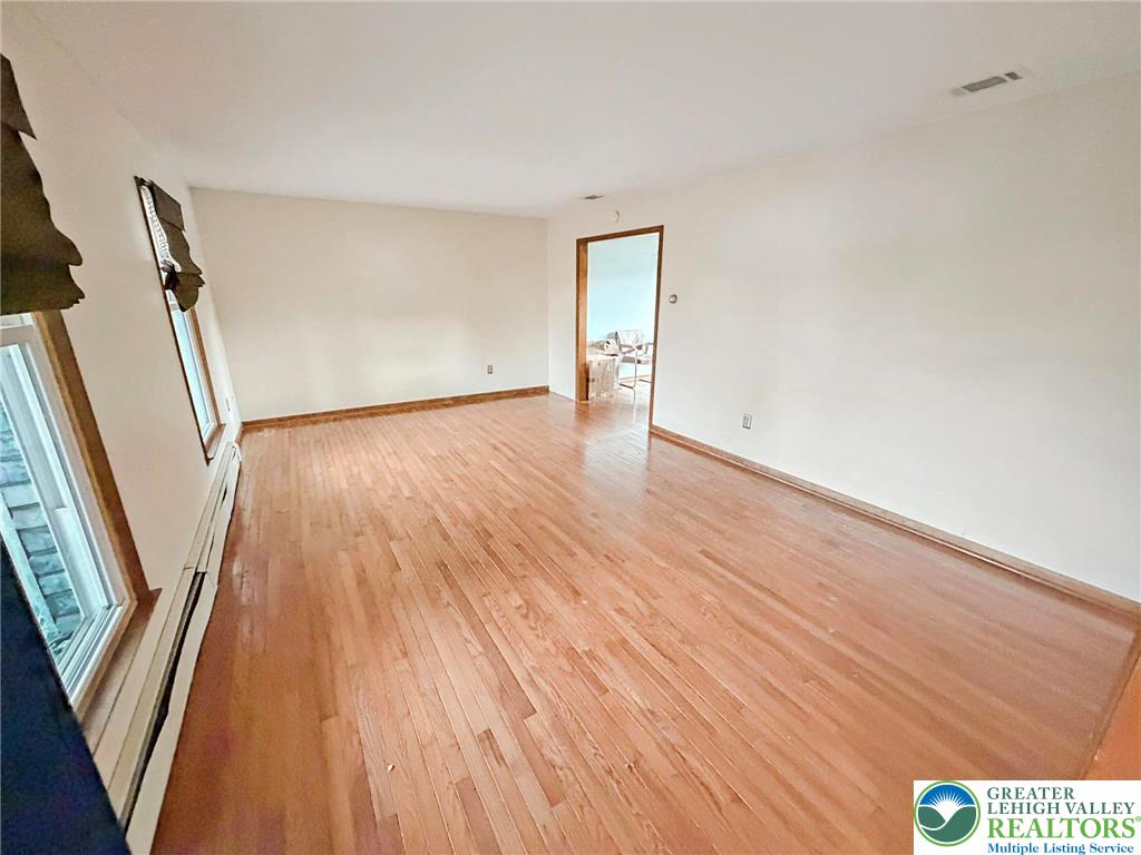 719 Hunter Street Catasauqua, PA 18032 - Photo 13 of 41 a view of an empty room with wooden floor and a window