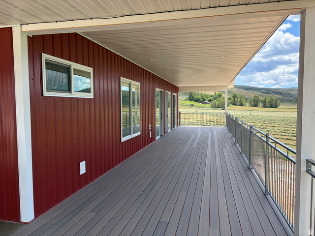 1325 South Round Road East Laketown, UT 84038 - Photo 4 of 40 Expansive covered deck featuring composite decking, gray metal railing, and recessed lighting