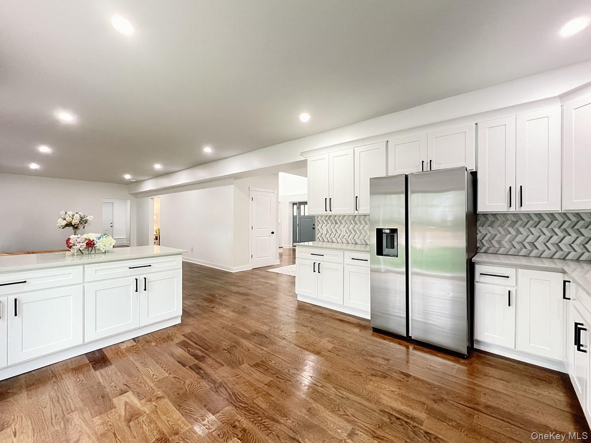 82 Hampton Road Marlboro, NY 12542 - Photo 8 of 39 Spacious kitchen featuring white shaker cabinetry, stainless steel refrigerator, herringbone tile backsplash, and light-tone countertops