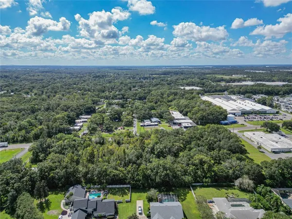 an aerial view of residential houses with outdoor space and trees