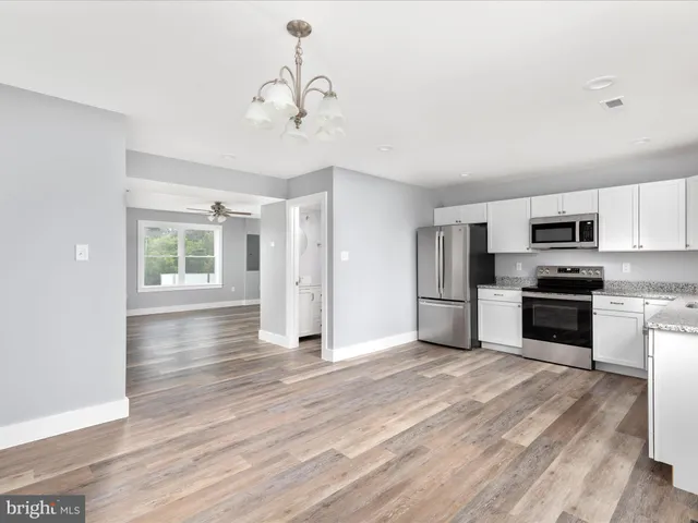 a kitchen with stainless steel appliances a refrigerator and a stove top oven