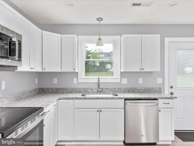 a kitchen with granite countertop white cabinets white appliances and a granite counter tops