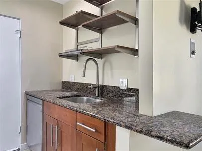 a bathroom with a granite countertop sink and a mirror