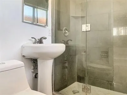 a bathroom with a sink a toilet and shower