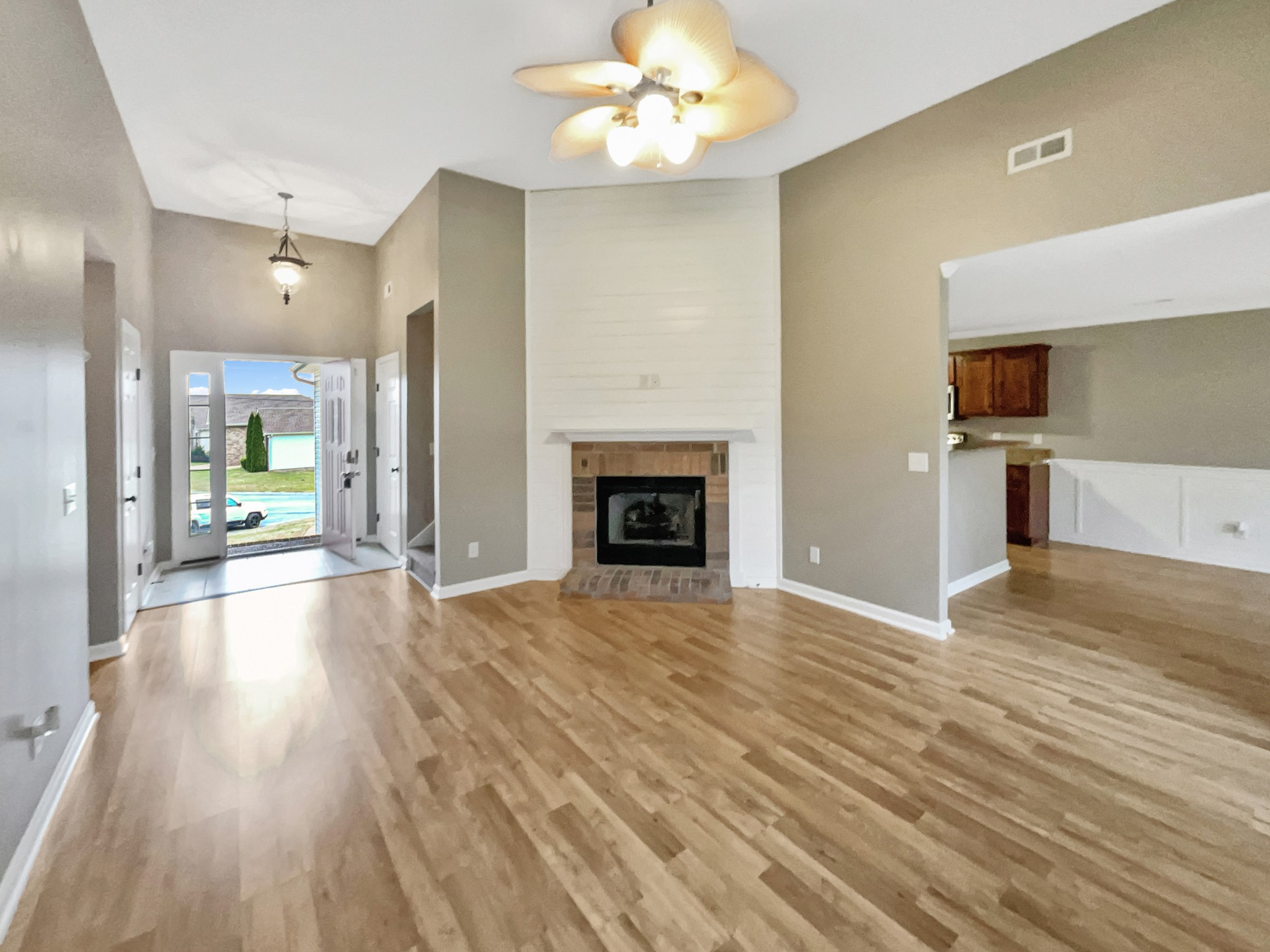 4022 Kristen Street Spring Hill, TN 37174 - Photo 5 of 23 a view of an empty room and kitchen with fireplace wooden floor