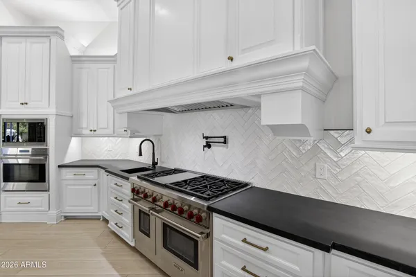 a living room with furniture kitchen view and a chandelier