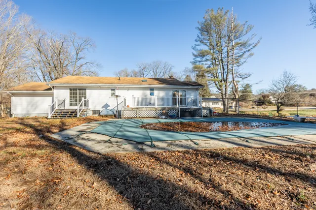 a view of a house with a yard and large trees