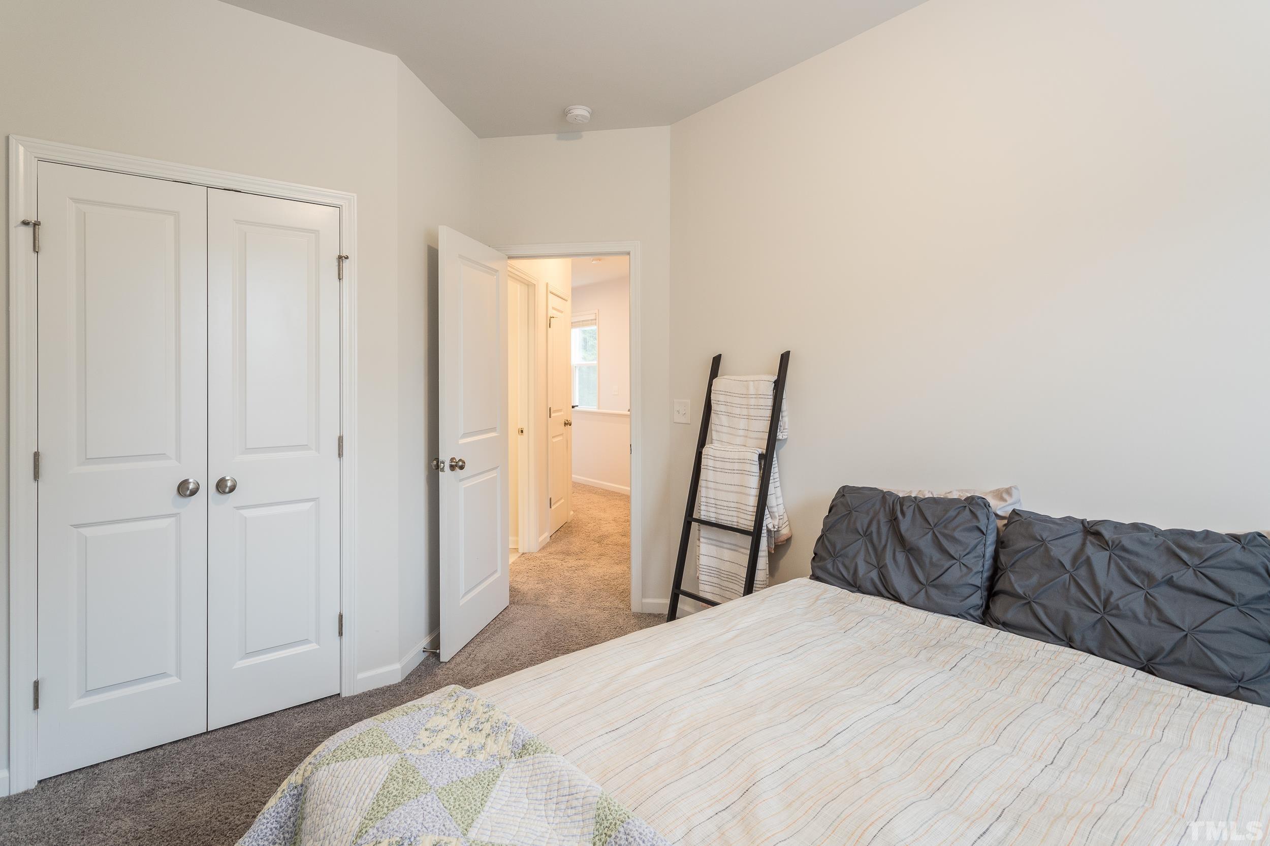 3700 Buffaloe Road Raleigh, NC 27604 - Photo 27 of 30 a bedroom with a bed and a chair