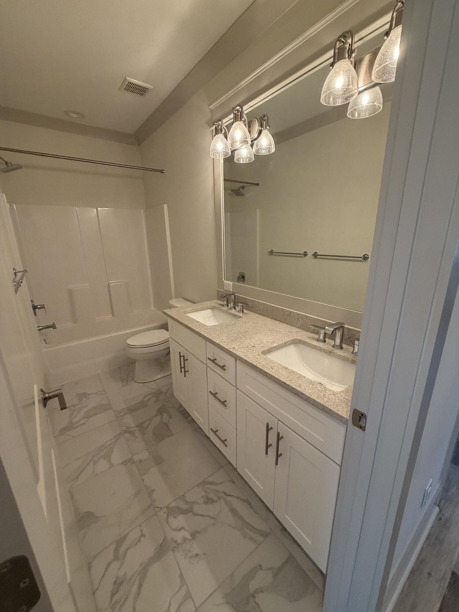 67 Heron's Crossing Santa Rosa Beach, FL 32459 - Photo 11 of 16 a bathroom with a granite countertop sink a mirror and a shower