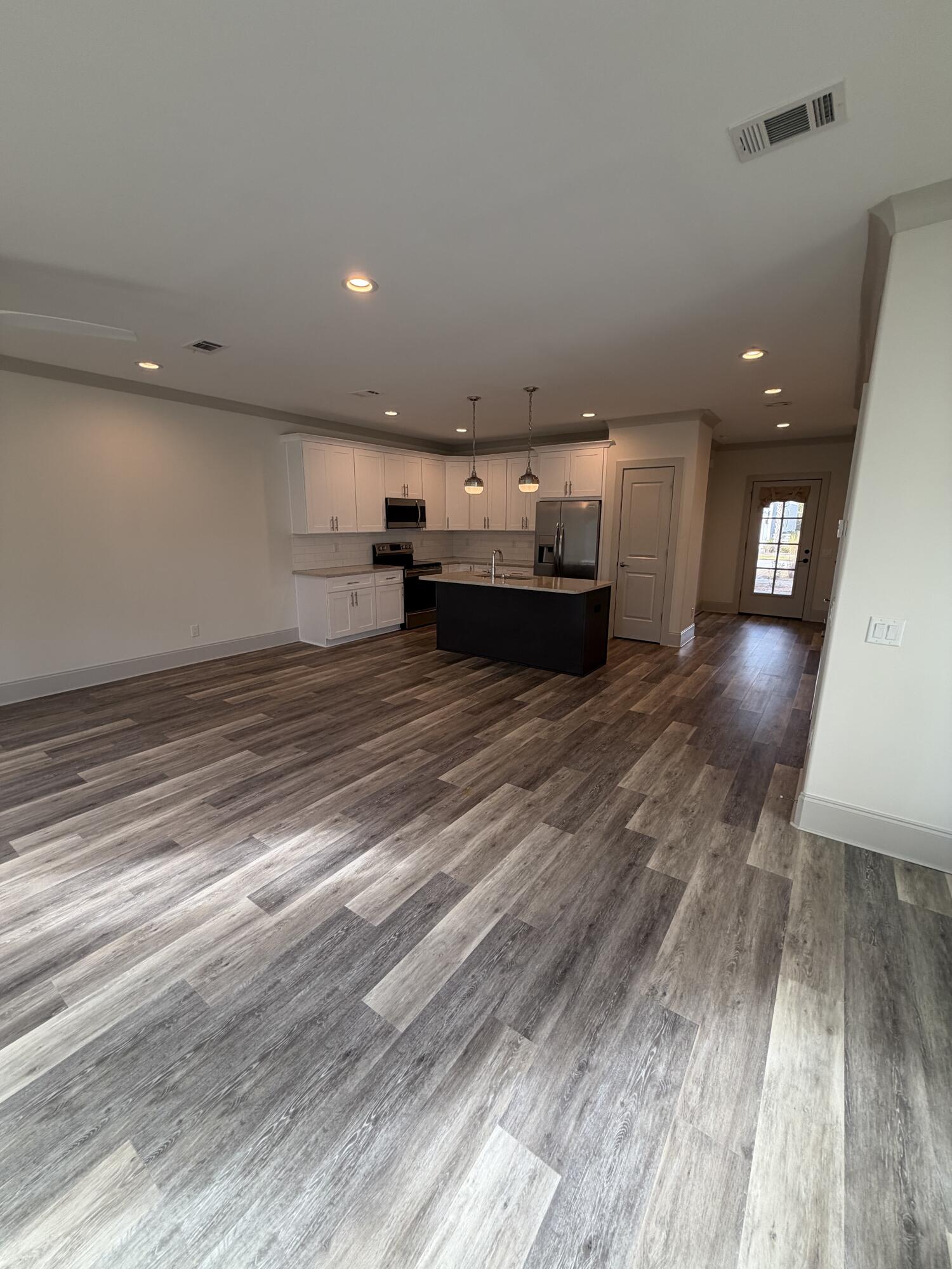 67 Heron's Crossing Santa Rosa Beach, FL 32459 - Photo 4 of 16 a view of a kitchen with a sink and dishwasher oven with wooden floor