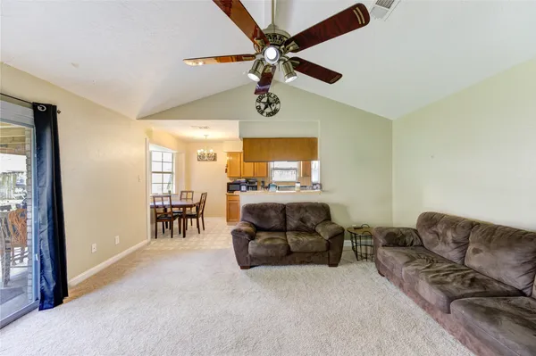 a living room with furniture and a ceiling fan
