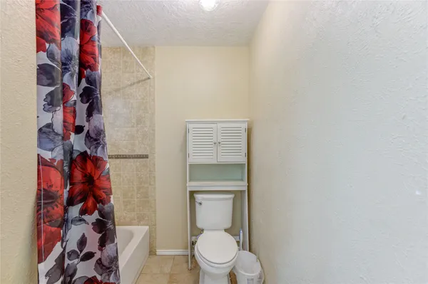a bathroom with a toilet and a shower curtain