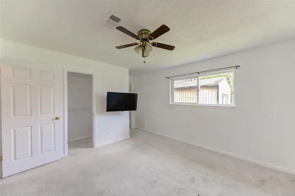 a living room with a ceiling fan and a window