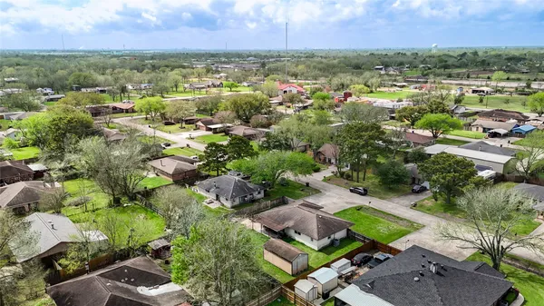 an aerial view of residential houses with outdoor space and trees