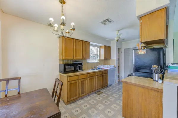 a kitchen that has a lot of cabinets and stainless steel appliances