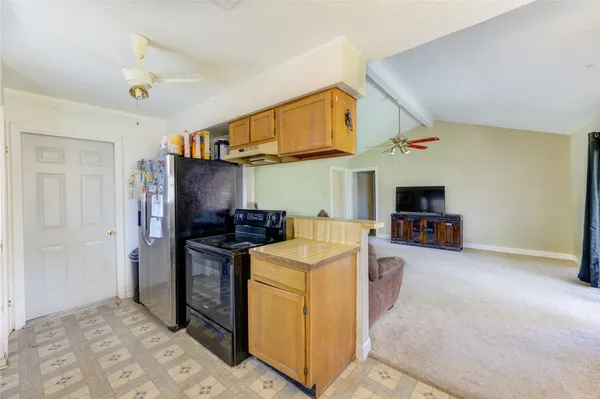 a view of a kitchen with stainless steel appliances granite countertop a refrigerator and a stove top oven