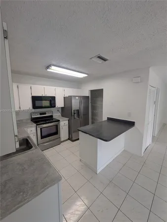 a kitchen with stainless steel appliances a stove a microwave and a refrigerator