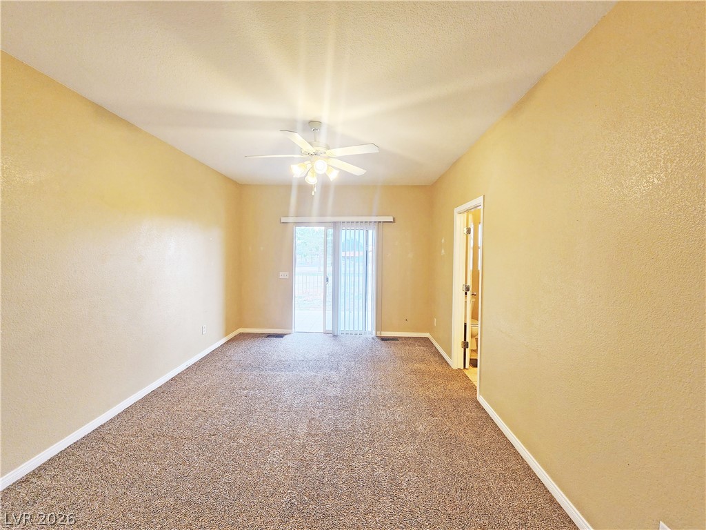1421 Star Road, Unit 2 Pahrump, NV 89048 - Photo 23 of 33 Unfurnished room with carpet flooring, ceiling fan, a textured wall, and baseboards