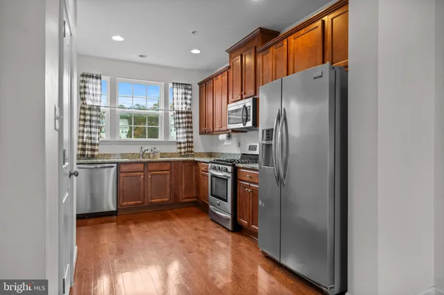 a kitchen with stainless steel appliances granite countertop a refrigerator and a sink