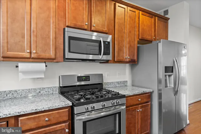 a kitchen with stainless steel appliances granite countertop a stove microwave refrigerator and sink