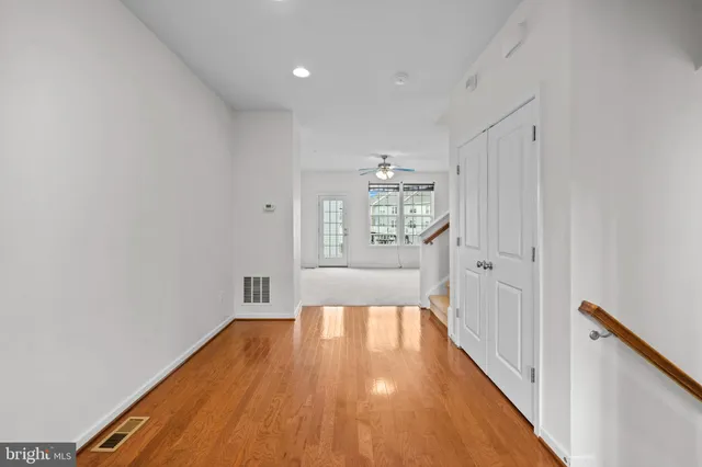 a view of a big room with wooden floor and windows