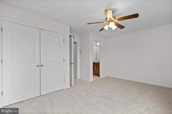 a view of an empty room and chandelier fan