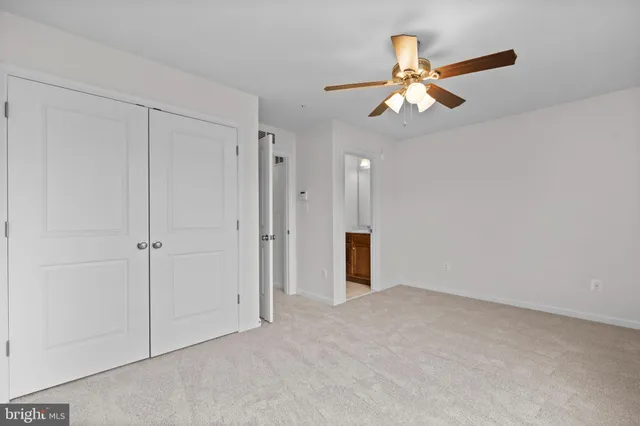 a view of an empty room and chandelier fan