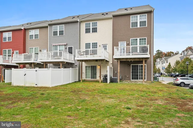 a view of a white house with a large window and yard