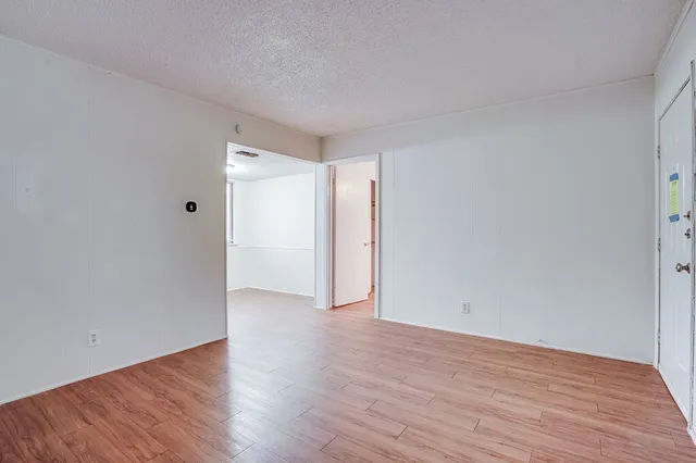 a view of an empty room with wooden floor