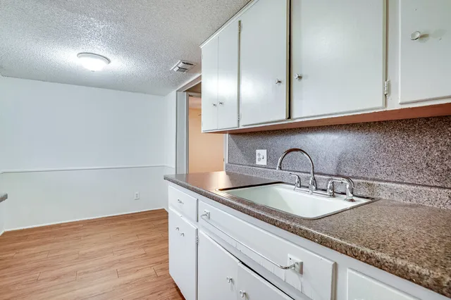 a kitchen with granite countertop stainless steel appliances sink and cabinets