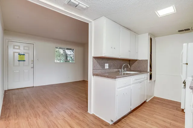a kitchen with granite countertop a sink and a stove top oven