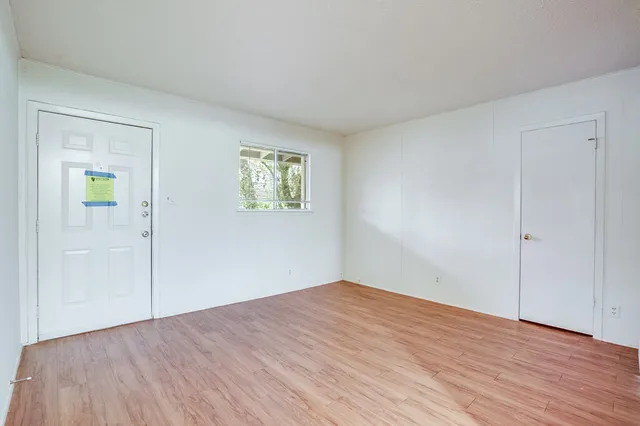 a view of empty room with wooden floor