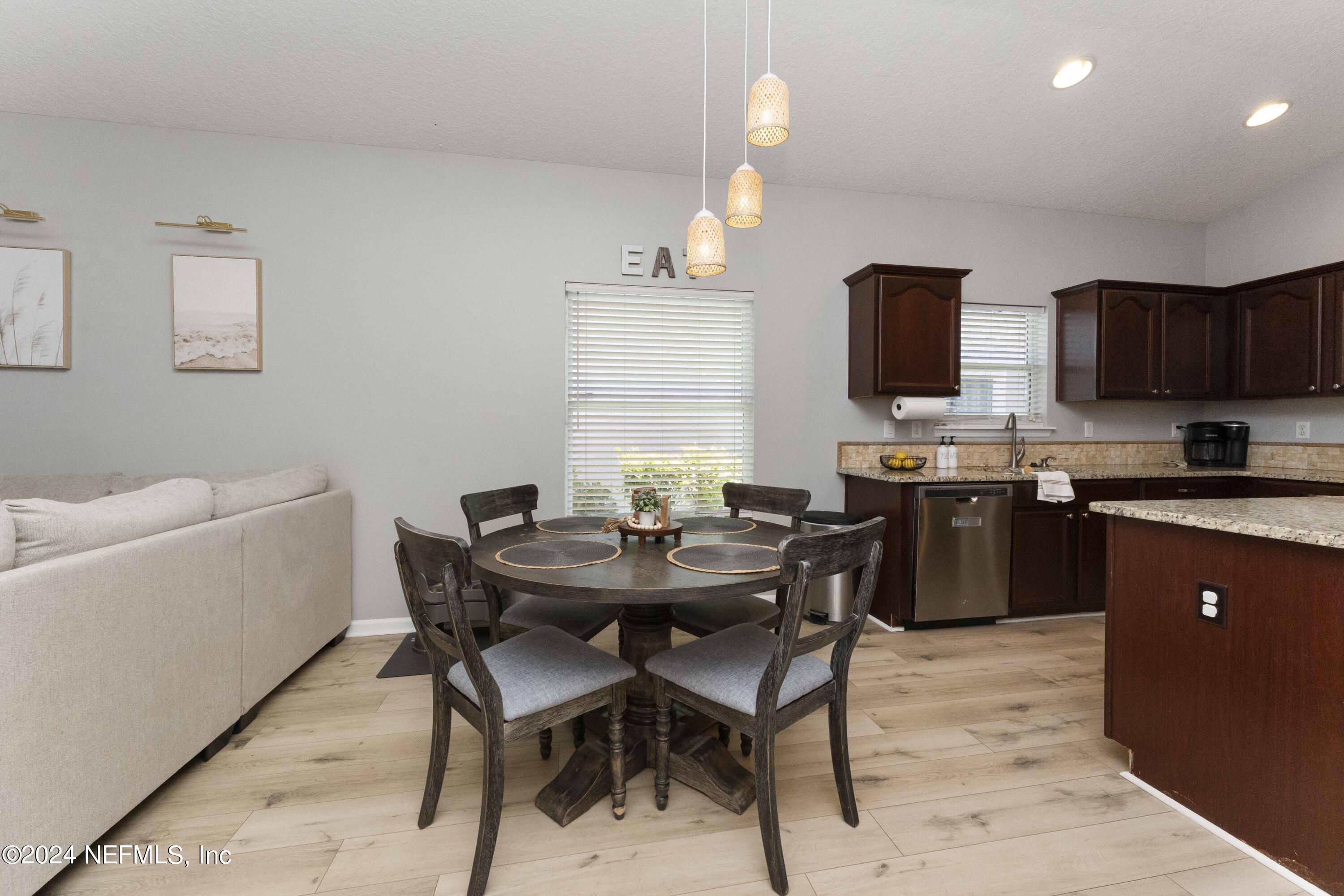 14498 Falling Waters Drive Jacksonville, FL 32258 - Photo 12 of 54 a kitchen with stainless steel appliances kitchen island granite countertop a sink a stove a table and chairs