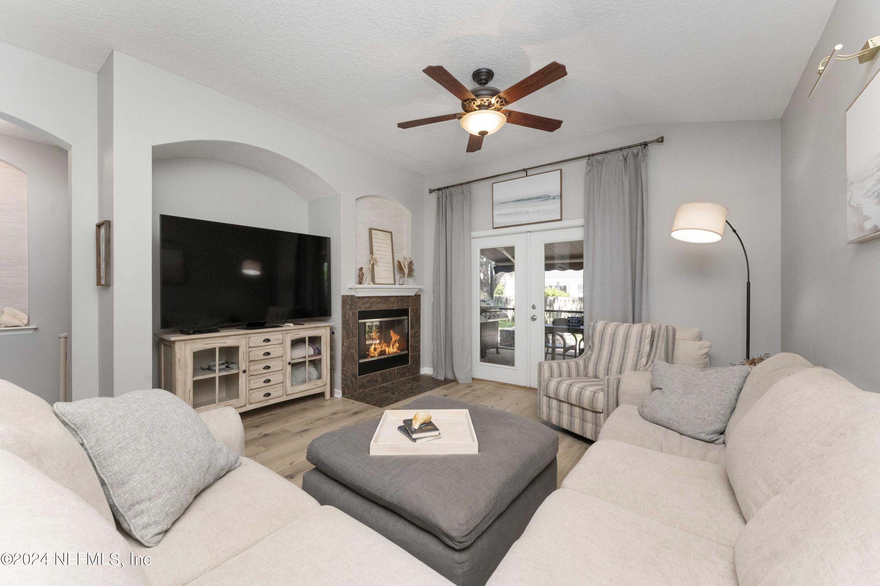 14498 Falling Waters Drive Jacksonville, FL 32258 - Photo 14 of 54 a living room with furniture a flat screen tv and a fireplace