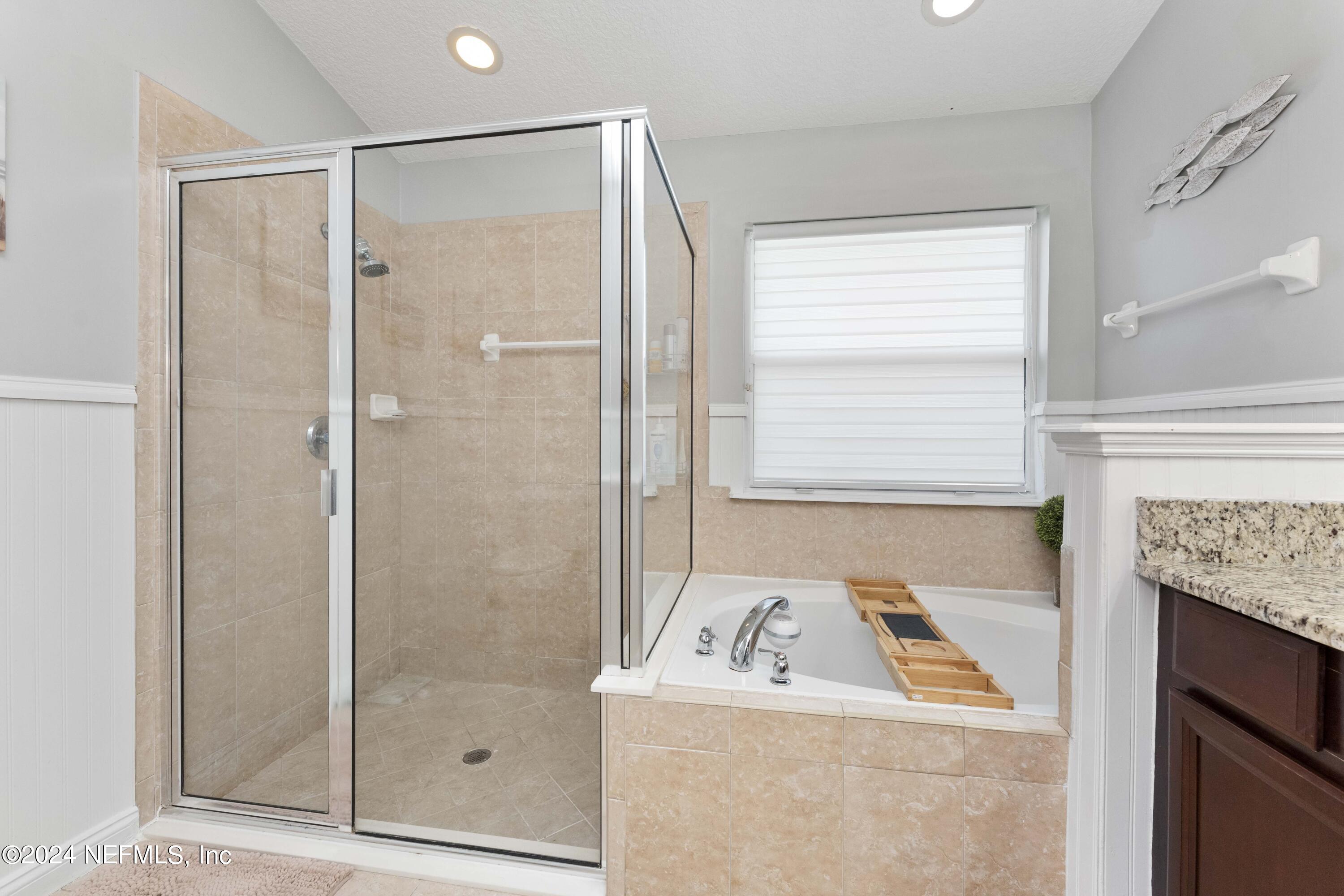 14498 Falling Waters Drive Jacksonville, FL 32258 - Photo 18 of 54 a bathroom with a shower a sink and a mirror