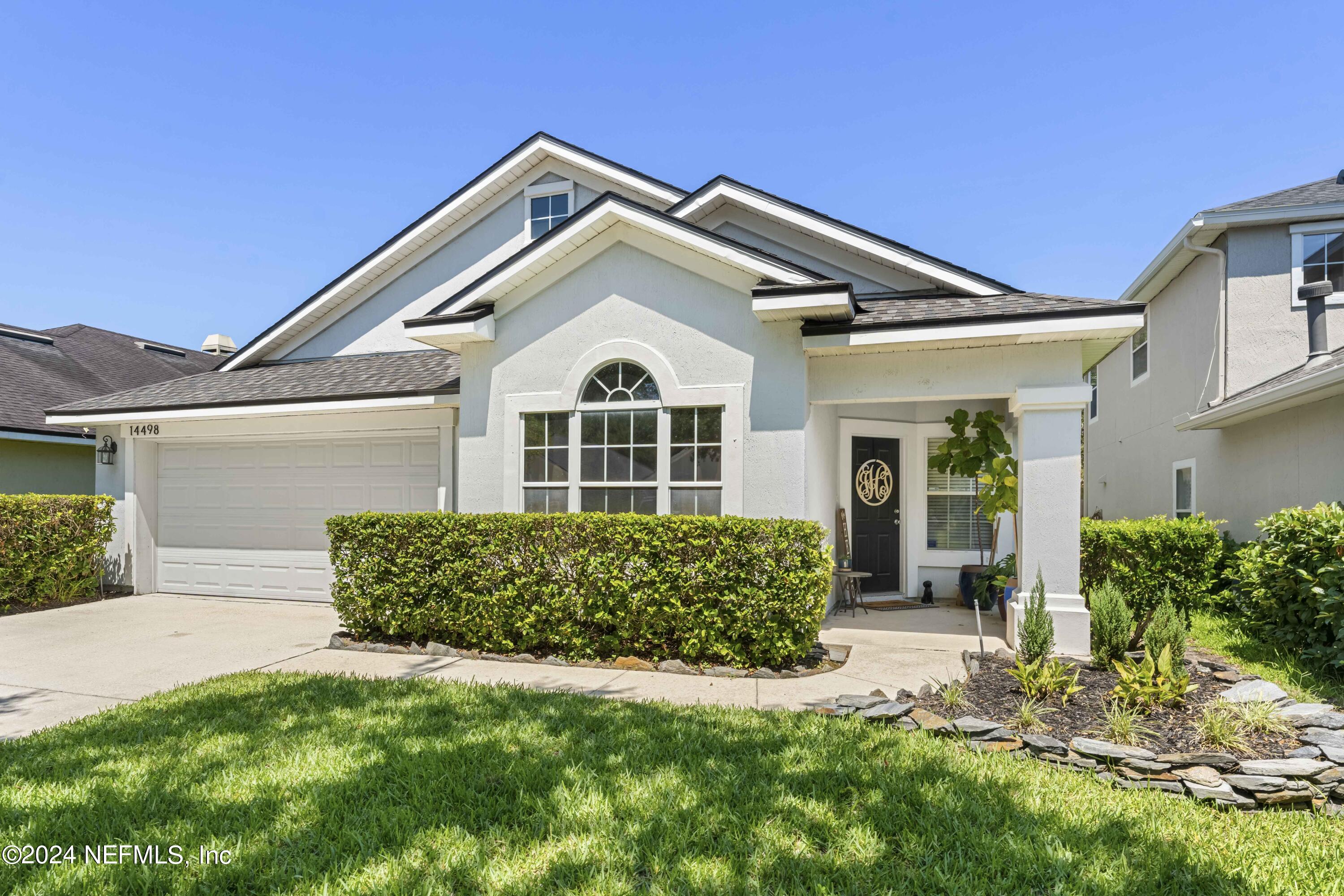 14498 Falling Waters Drive Jacksonville, FL 32258 - Photo 2 of 54 a front view of a house with a garden