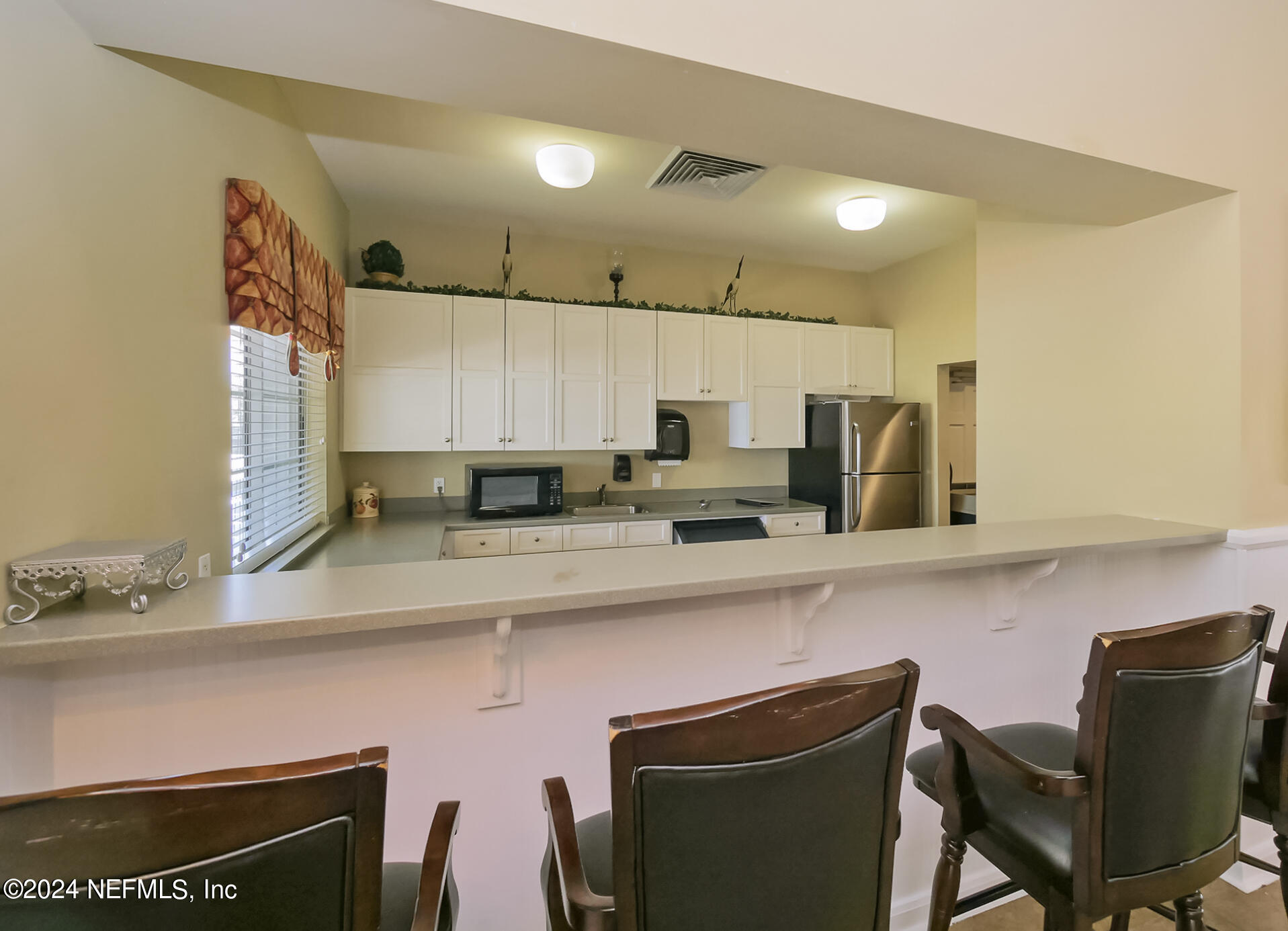 14498 Falling Waters Drive Jacksonville, FL 32258 - Photo 46 of 54 a kitchen with stainless steel appliances a sink a stove a table and chairs