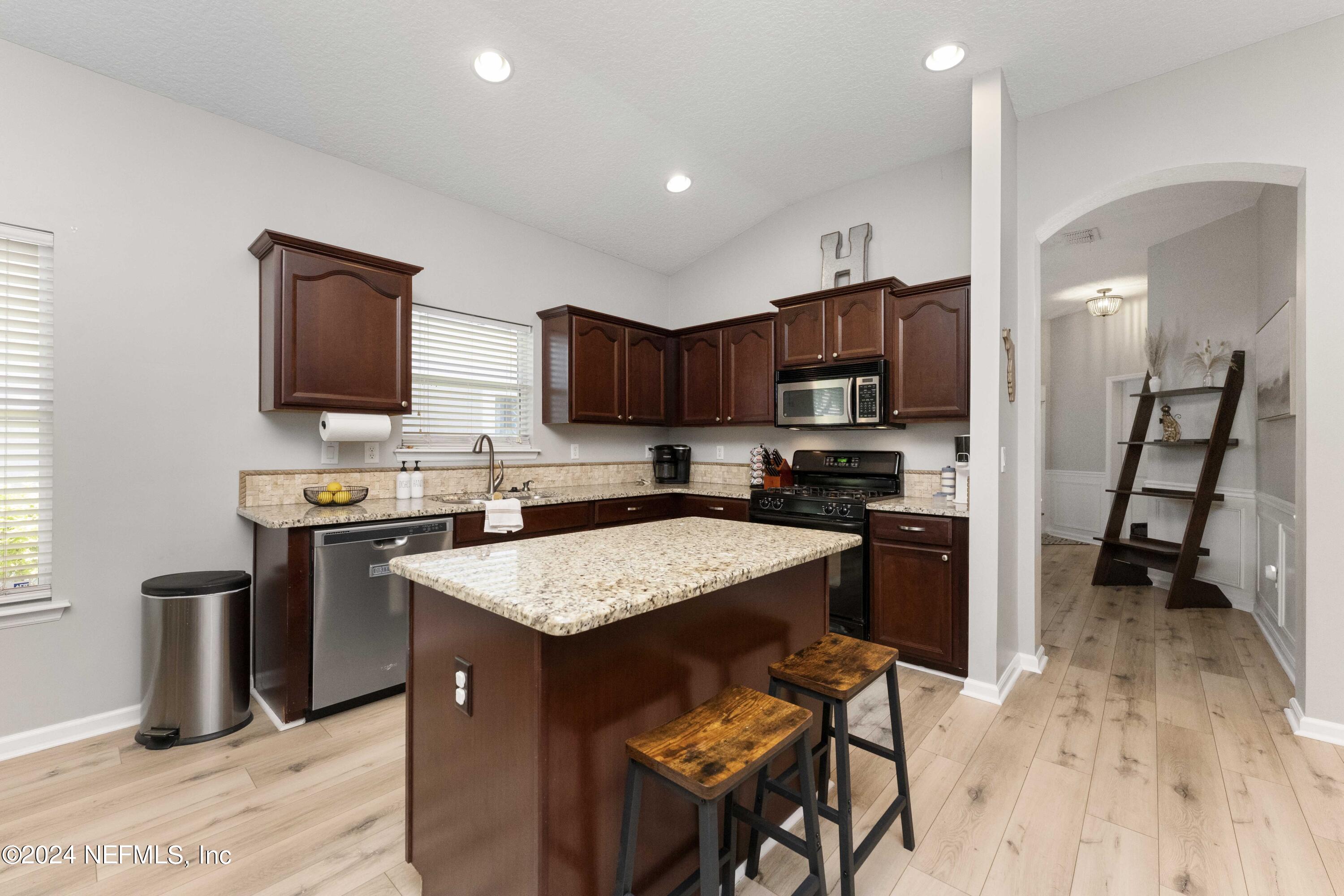 14498 Falling Waters Drive Jacksonville, FL 32258 - Photo 9 of 54 a kitchen with stainless steel appliances granite countertop a stove top oven a sink dishwasher a dining table and chairs with wooden floor