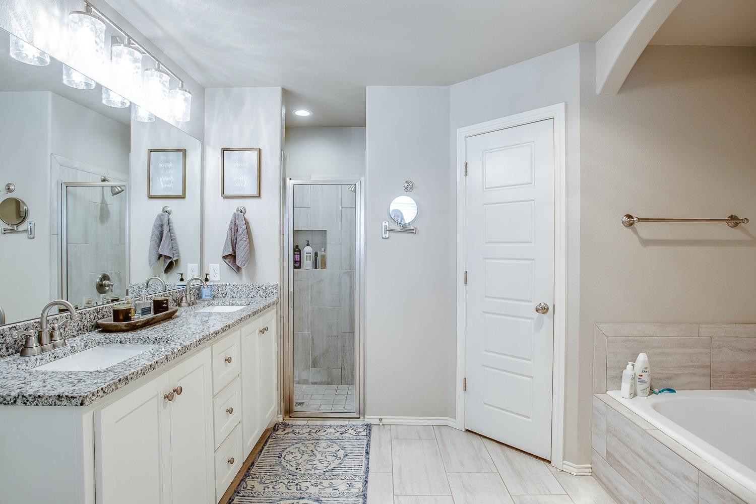 3911 127th Street Lubbock, TX 79423 - Photo 18 of 33 a spacious bathroom with a granite countertop sink mirror and a