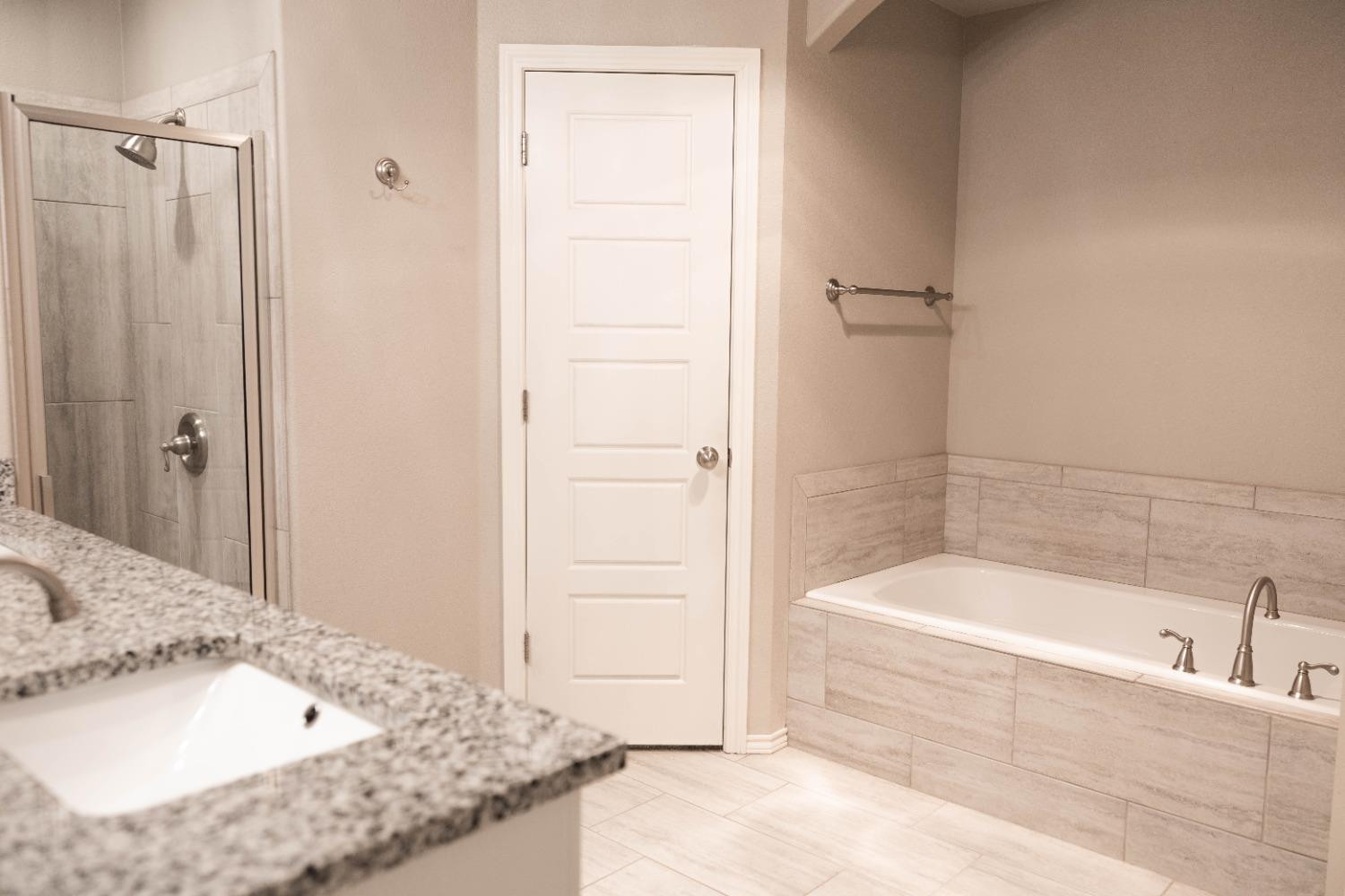 3911 127th Street Lubbock, TX 79423 - Photo 20 of 33 a bathroom with a granite countertop bathtub sink and vanity